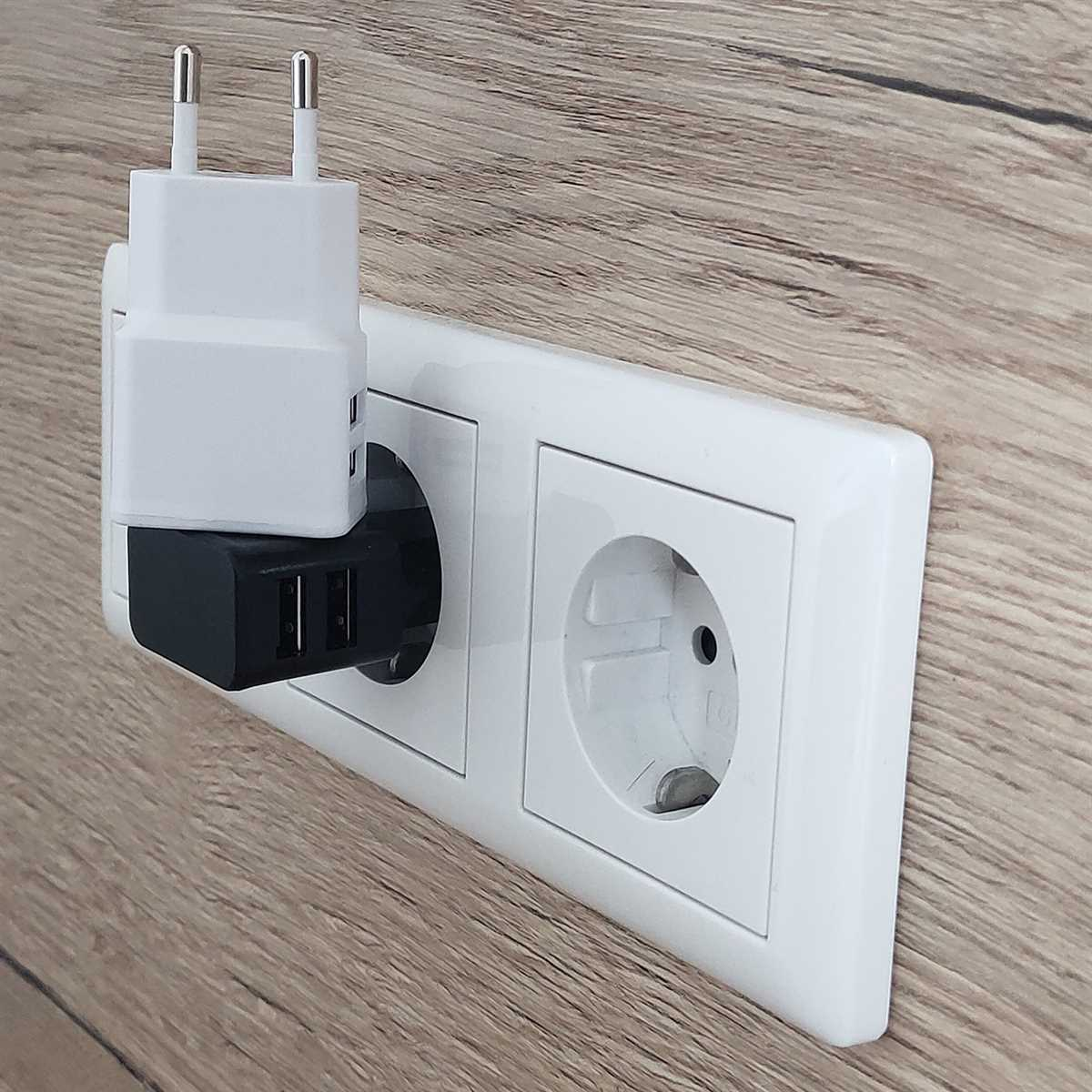 Weiße Steckdose mit zwei Steckdosen, mit zwei eingesteckten Ladegeräten. Holzmaserung im Hintergrund.