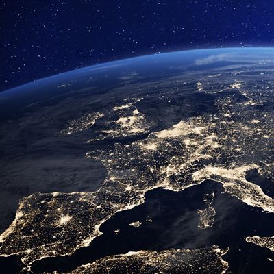Die Erde bei Nacht, zeigt Stadtlichter über Europa. Dunkelblauer Himmel, klare Sicht.