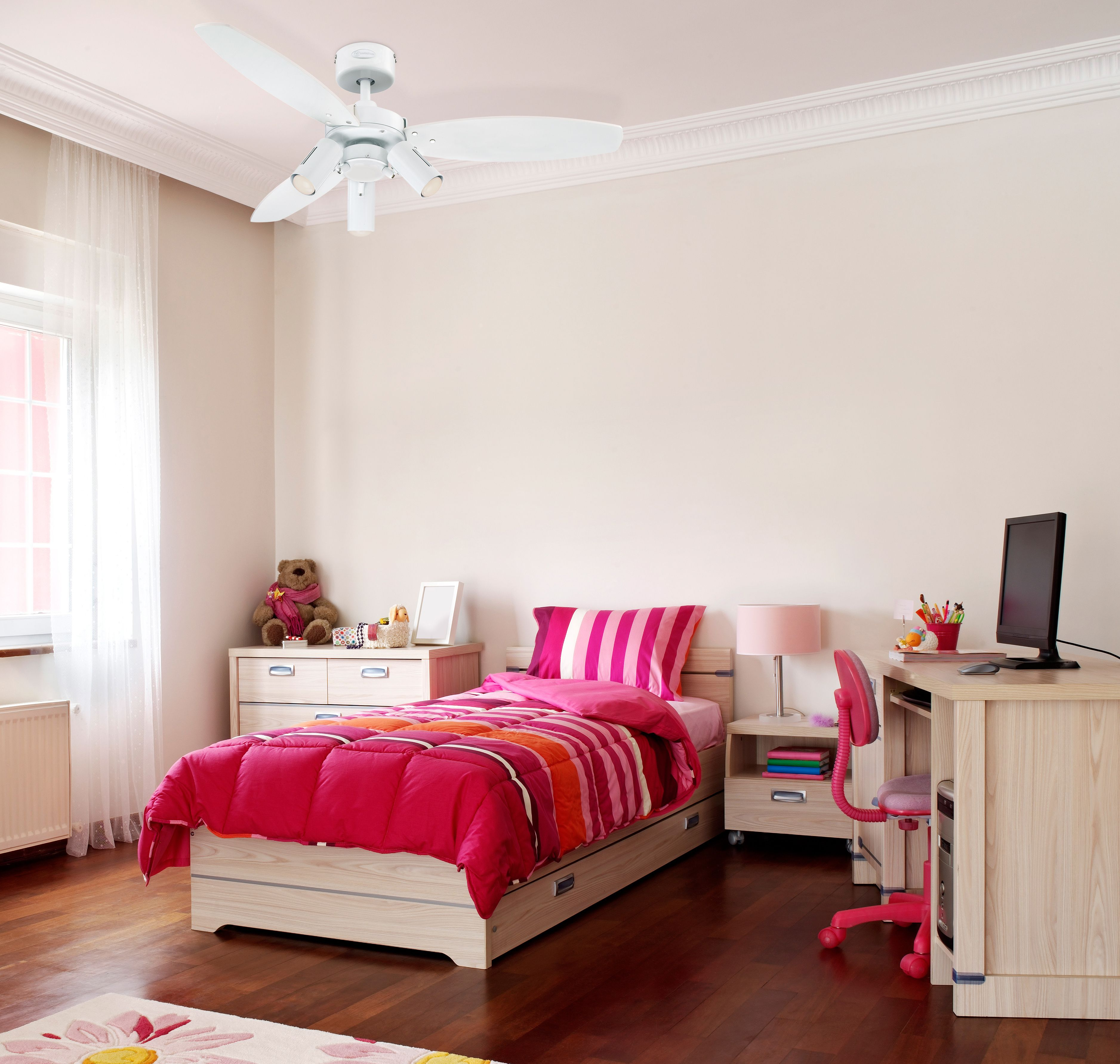 Una cameretta con lenzuola rosa, una scrivania, una sedia e un ventilatore a soffitto.