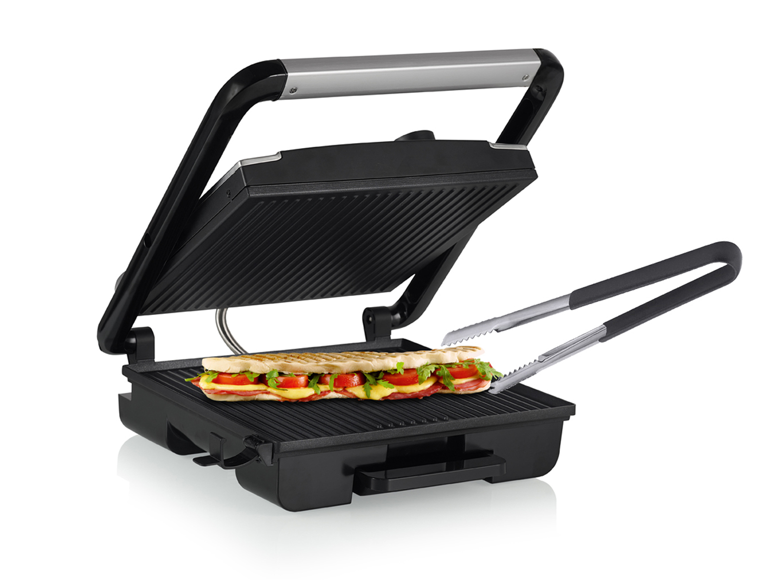 Ein schwarzer Sandwichgrill mit einem Sandwich darin. Zangen halten ein Sandwich.
