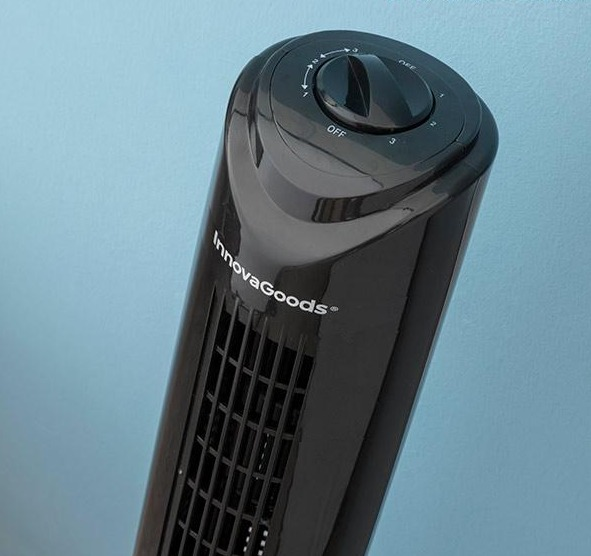 Schwarzer InnovaGoods-Turmventilator mit Drehregler vor hellblauer Wand.