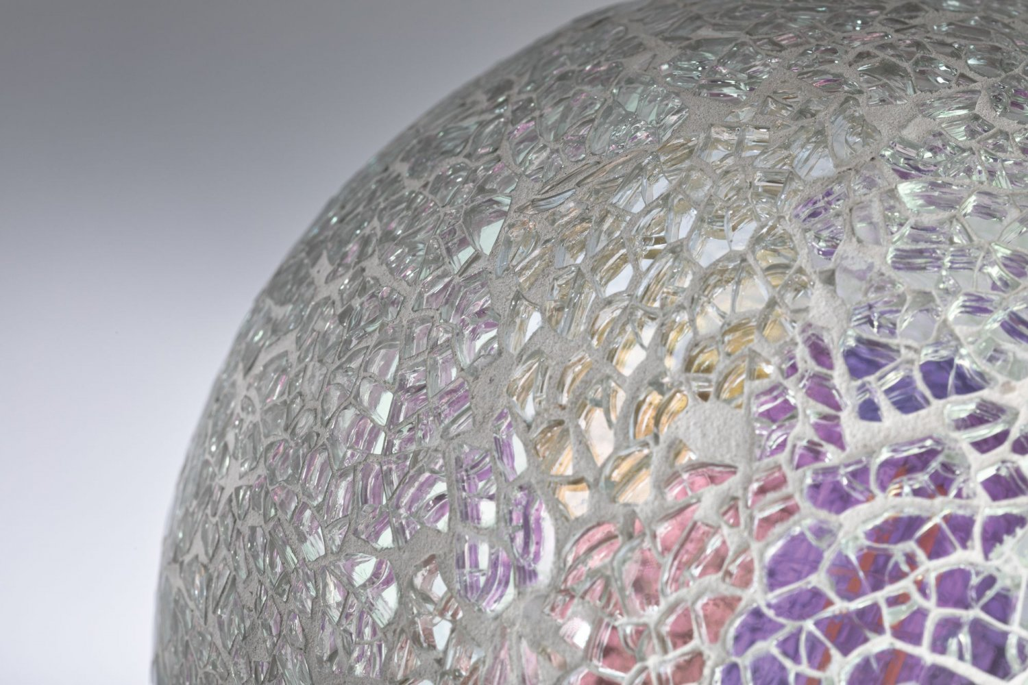 Zbliżenie na żarówkę mozaikową, pokazujące skomplikowaną teksturę pękniętego szkła.