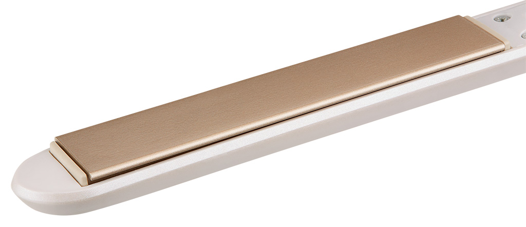 Zbliżenie białej i złotej prostownicy do włosów, widok pod kątem.