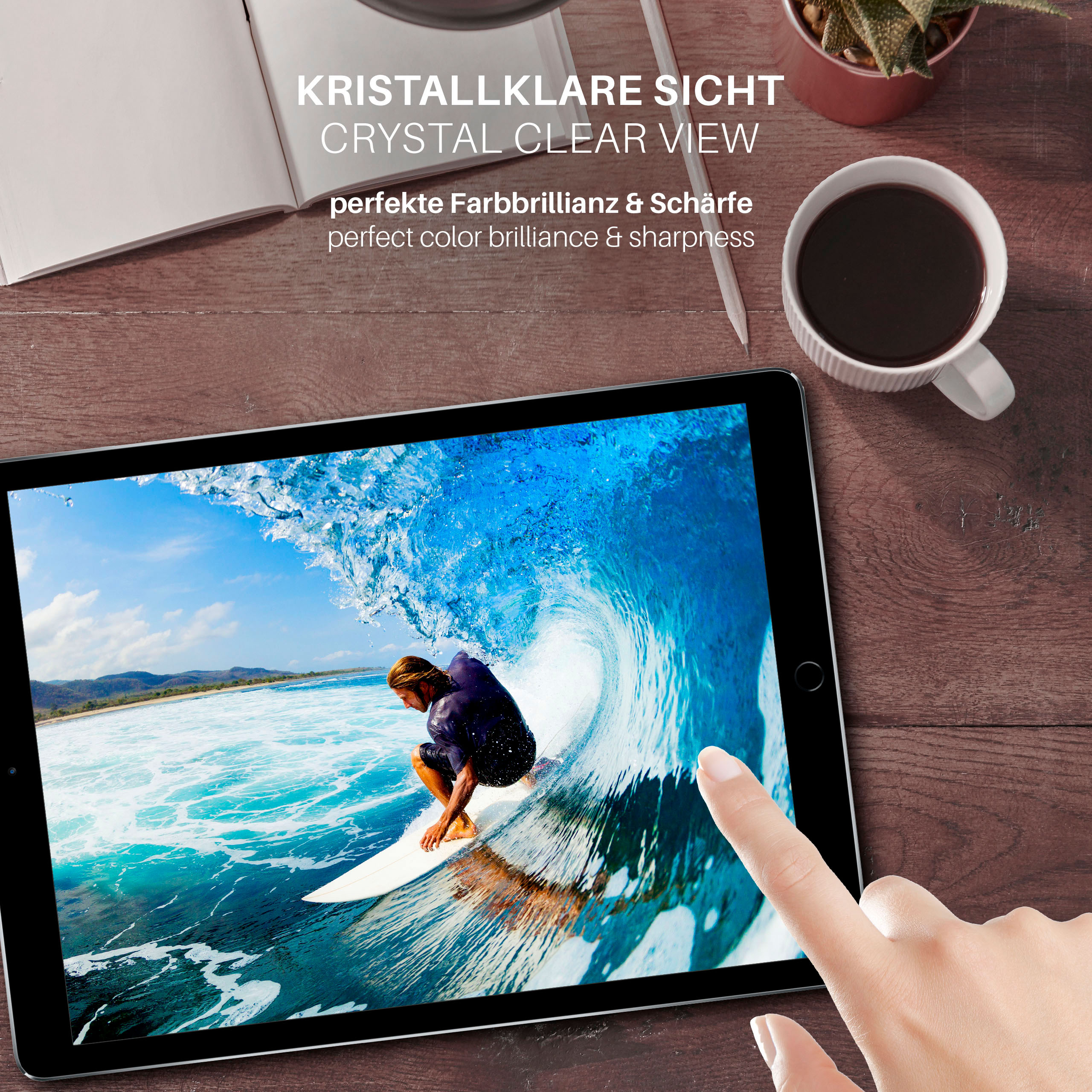 Ein Tablet zeigt einen Surfer auf einer Welle. Eine Hand berührt den Bildschirm. Eine Kaffeetasse, ein Stift und eine Pflanze sind vorhanden.