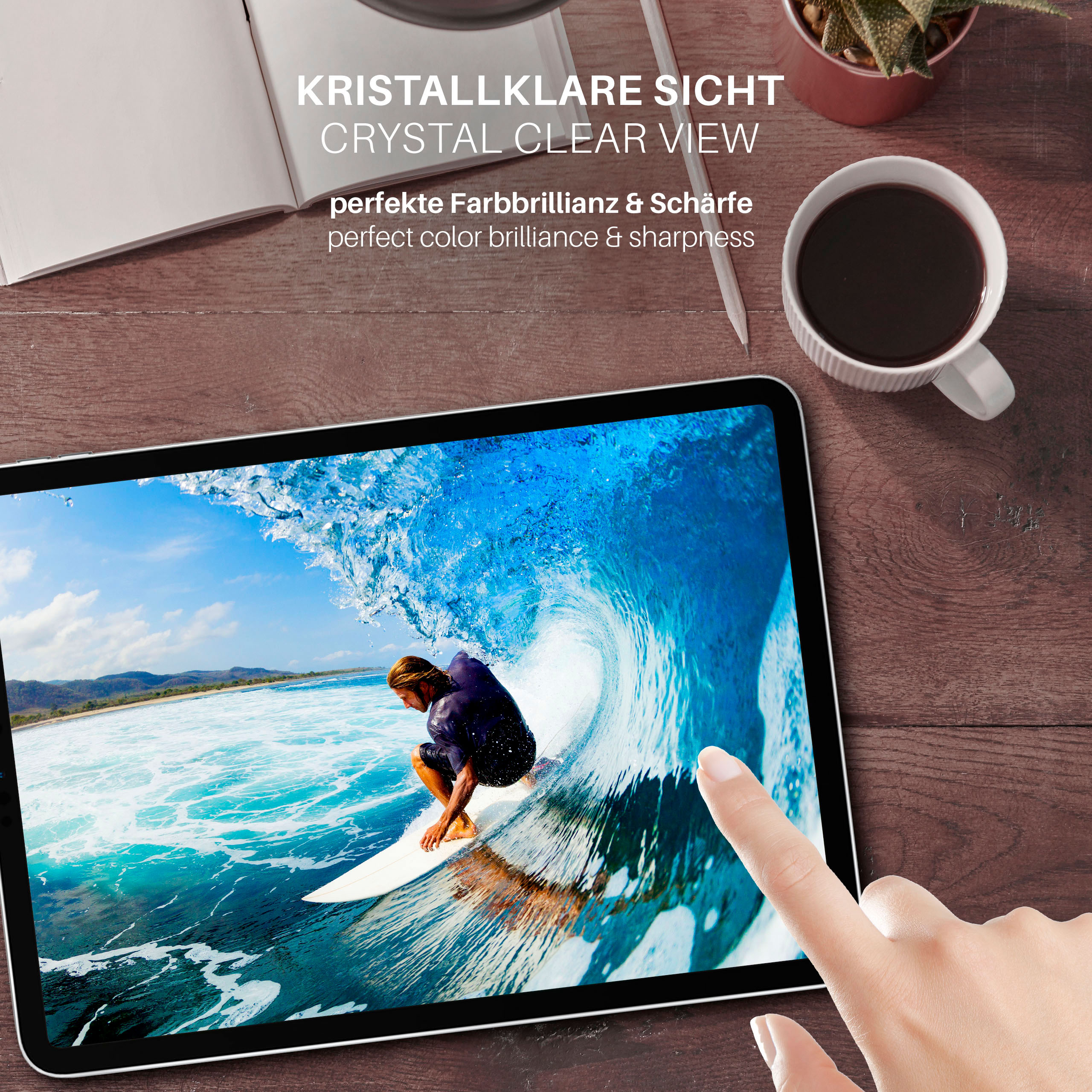 Tablet zeigt Surfer auf einer Welle. Hand berührt Bildschirm. Kaffeetasse, Pflanze und Stift auf Holztisch.