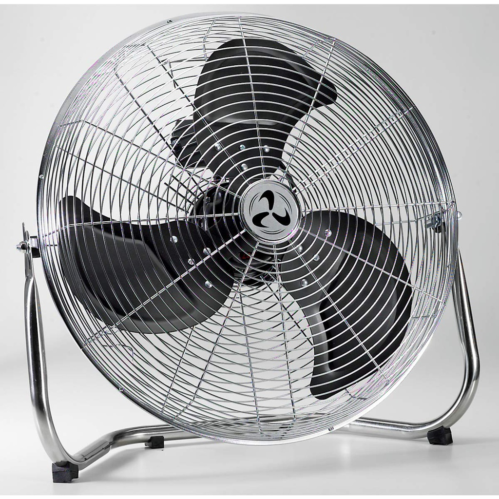 Ein großer Metallventilator mit schwarzen Flügeln. Es steht auf einem Metallständer. Der Lüfter befindet sich in einem weißen Raum.