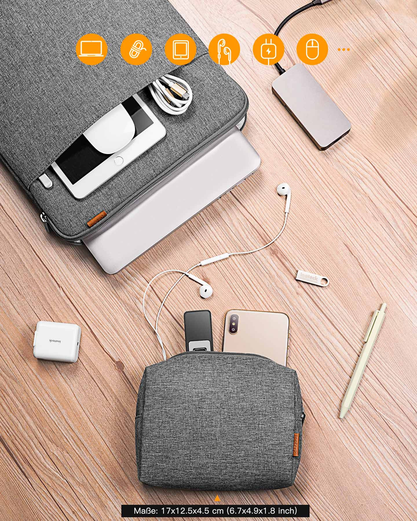 Graue Laptop-Hülle mit Zubehör: Telefon, Ohrhörer, Ladegerät, Stift, USB.