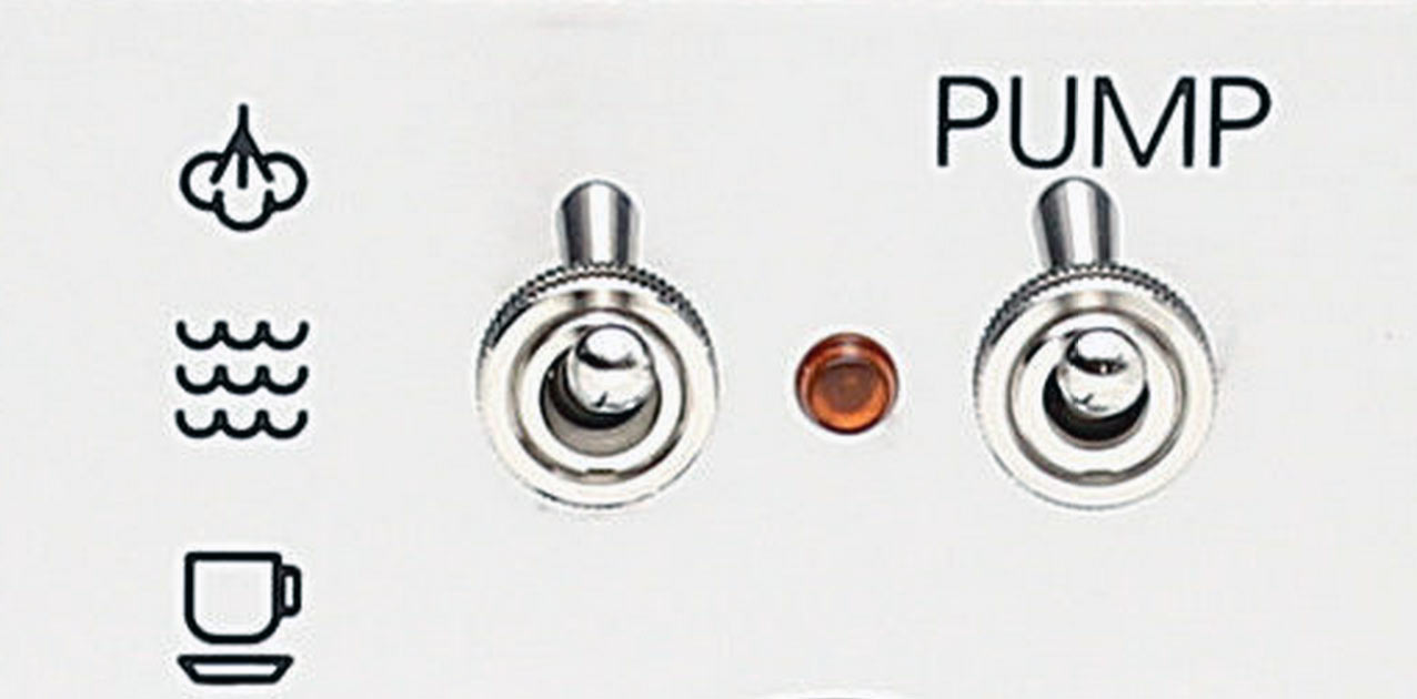 Biały panel sterowania maszyną z przełącznikami dźwigienkowymi i ikonami pary i pompy.