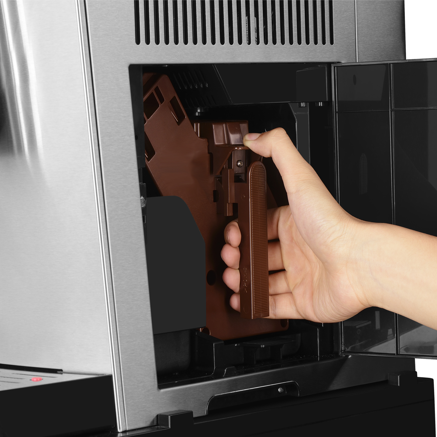 Eine Hand greift in eine Kaffeemaschine, um eine braune Komponente zu entfernen. Die Maschine ist Edelstahl.
