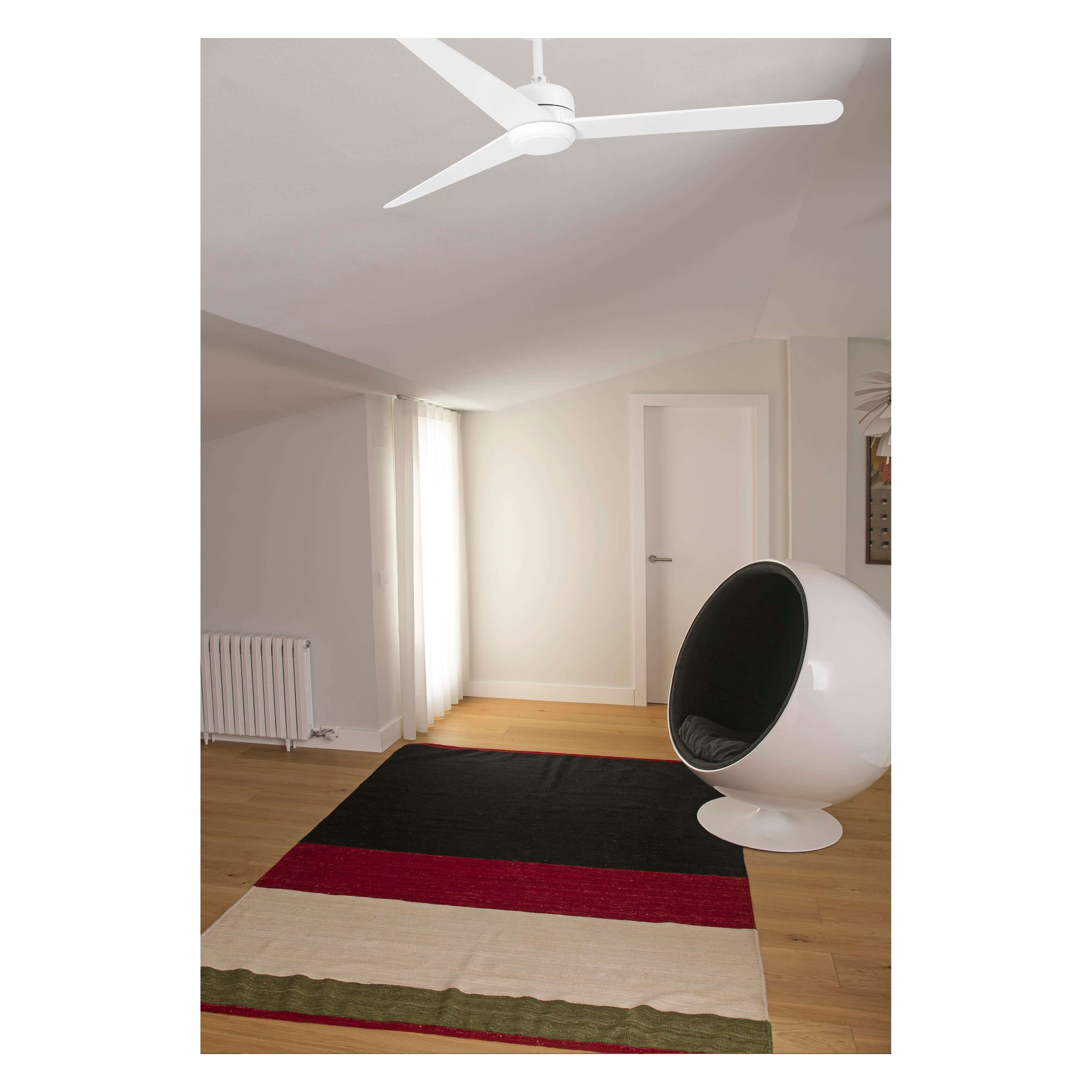Weißer Deckenventilator in einem Raum. Weiße Wände, Holzboden und ein Teppich. Moderner Stuhl.