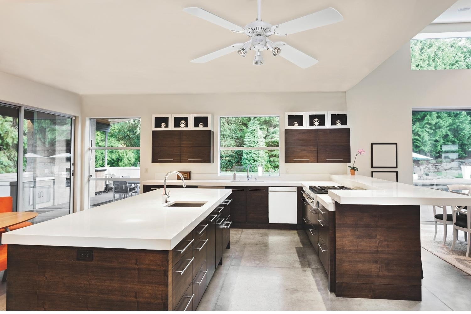 Una cucina moderna con ripiani bianchi, mobili in legno scuro e ventilatore a soffitto.