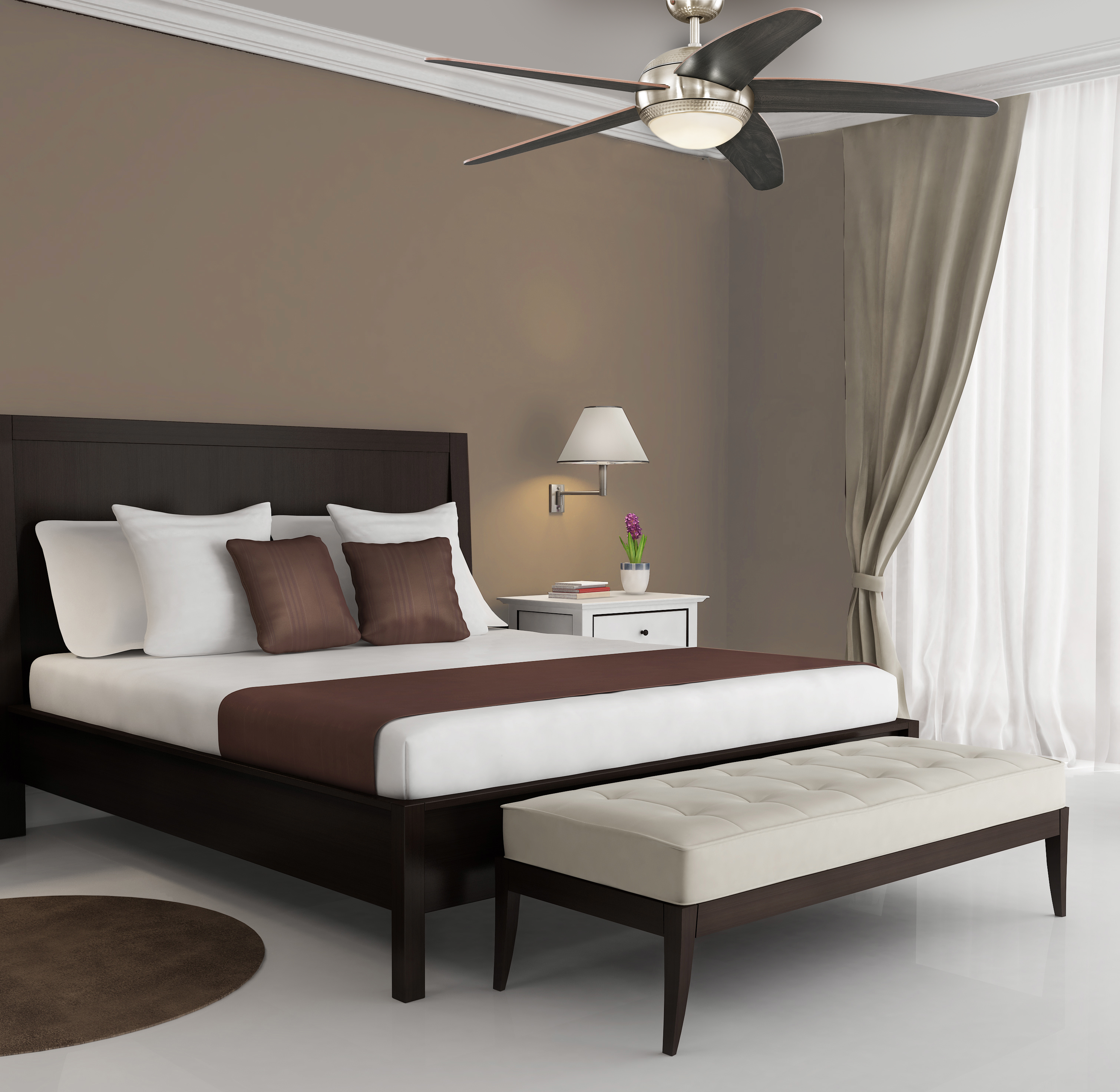 Schlafzimmer mit Bett, weißer Bettwäsche, braunem Kopfteil, Deckenventilator und Fenster mit Vorhängen.