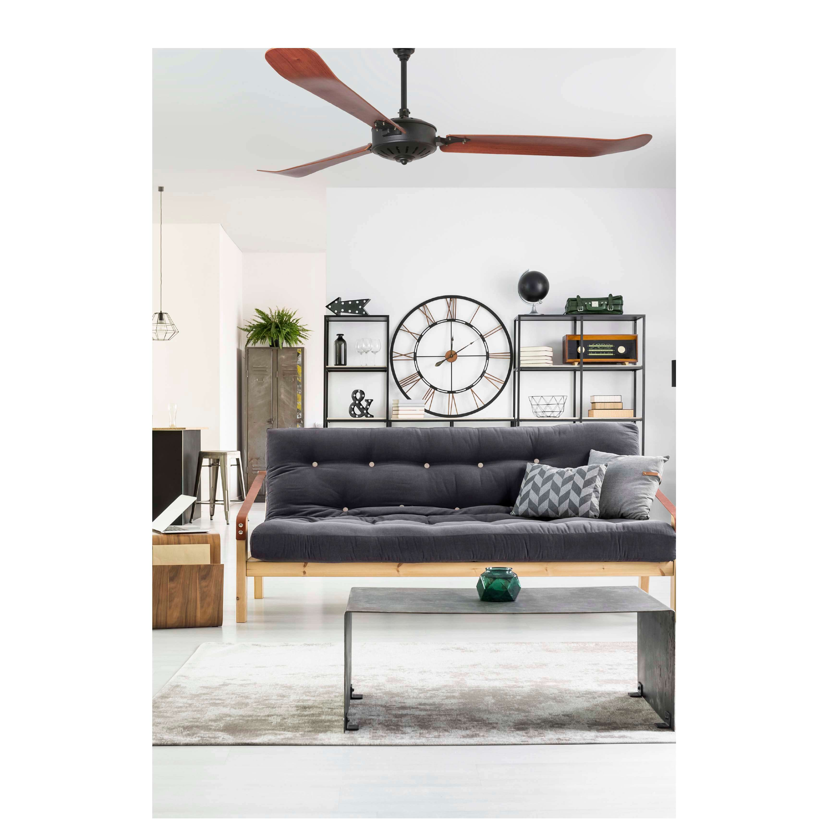 Wohnzimmerszene: Graues Sofa, Holztisch, schwarze Regale und Deckenventilator mit Holzflügeln.