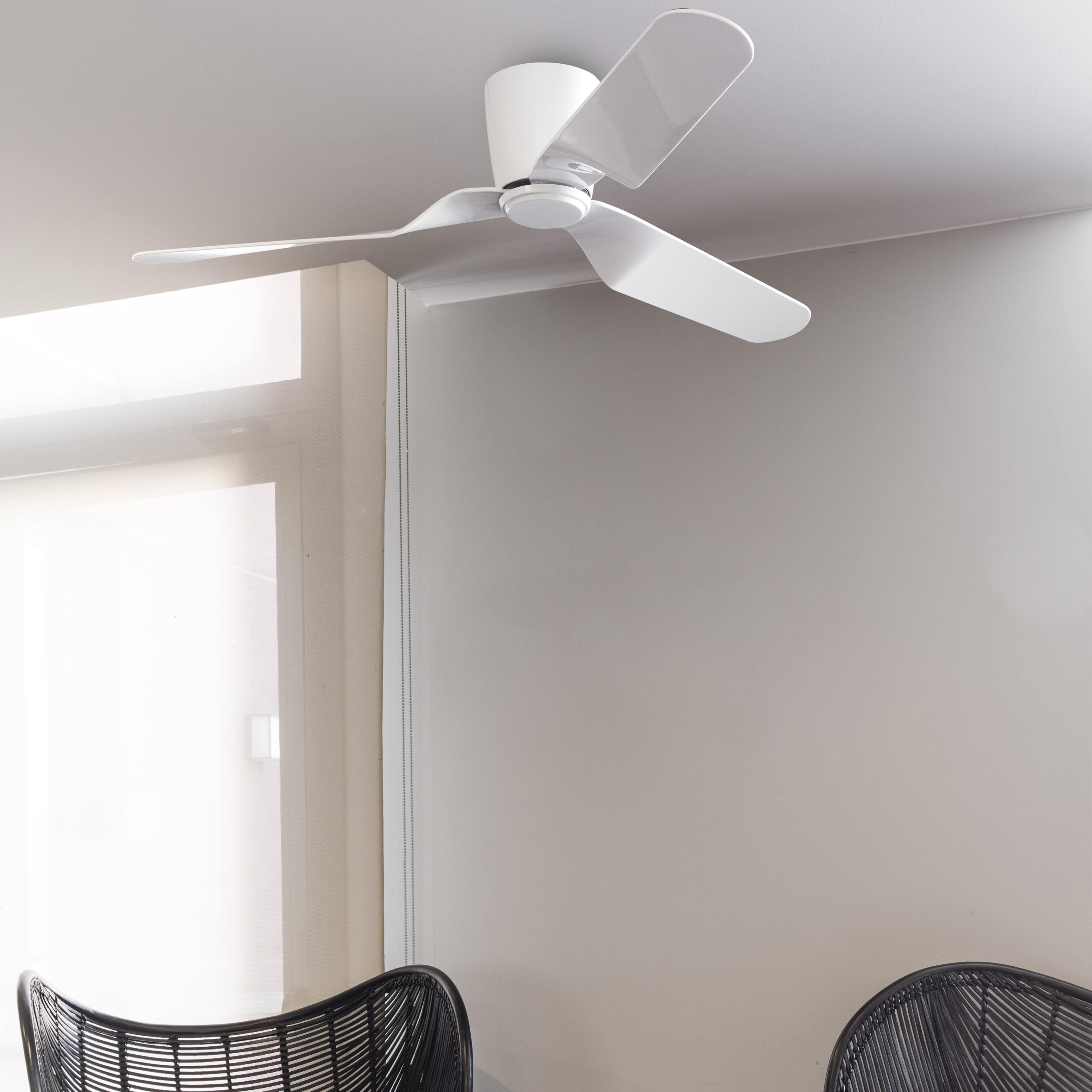 Ventilatore da soffitto bianco con tre pale. Pareti grigio chiaro e una sedia nera.