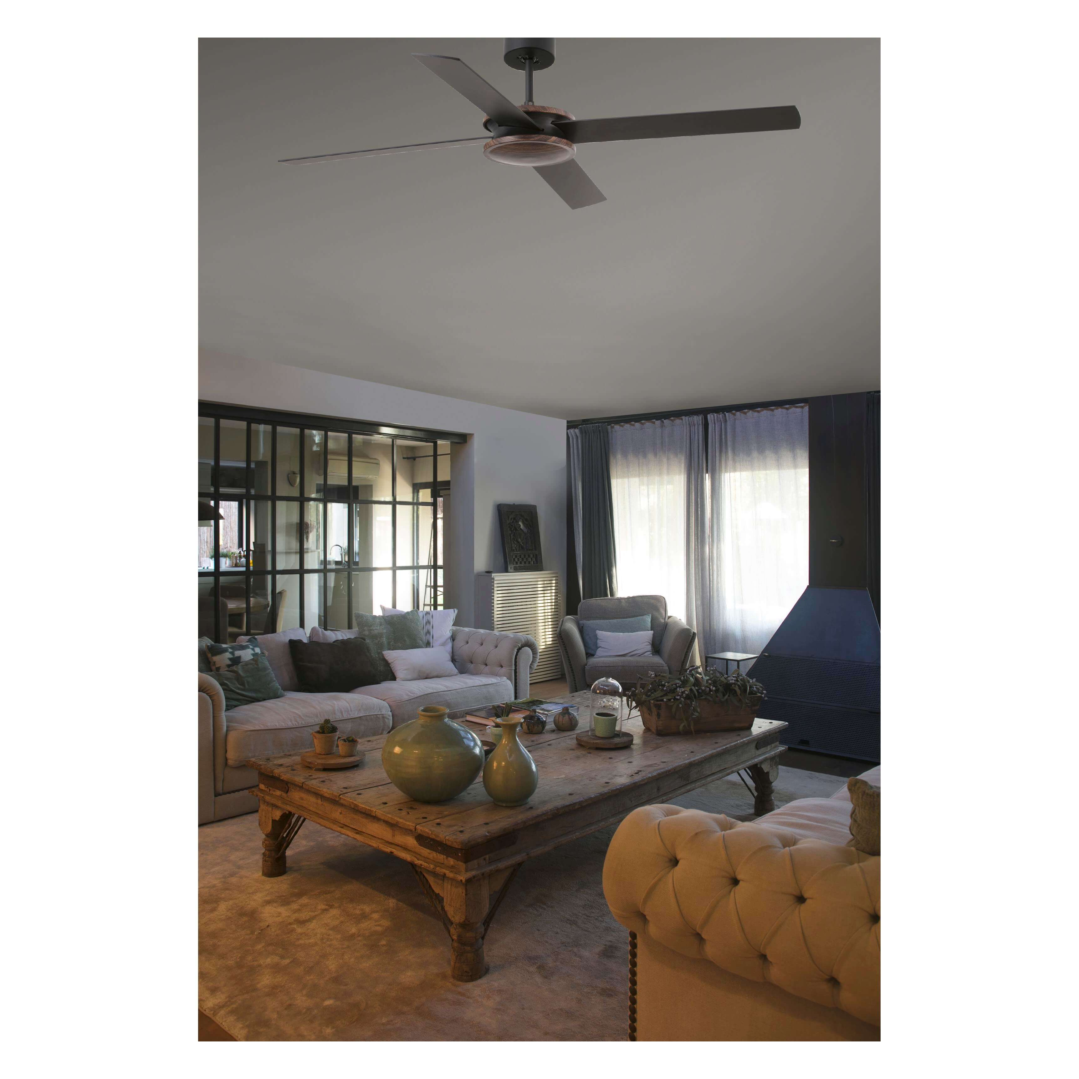 Scatto interno di un soggiorno con ventilatore a soffitto e mobili.