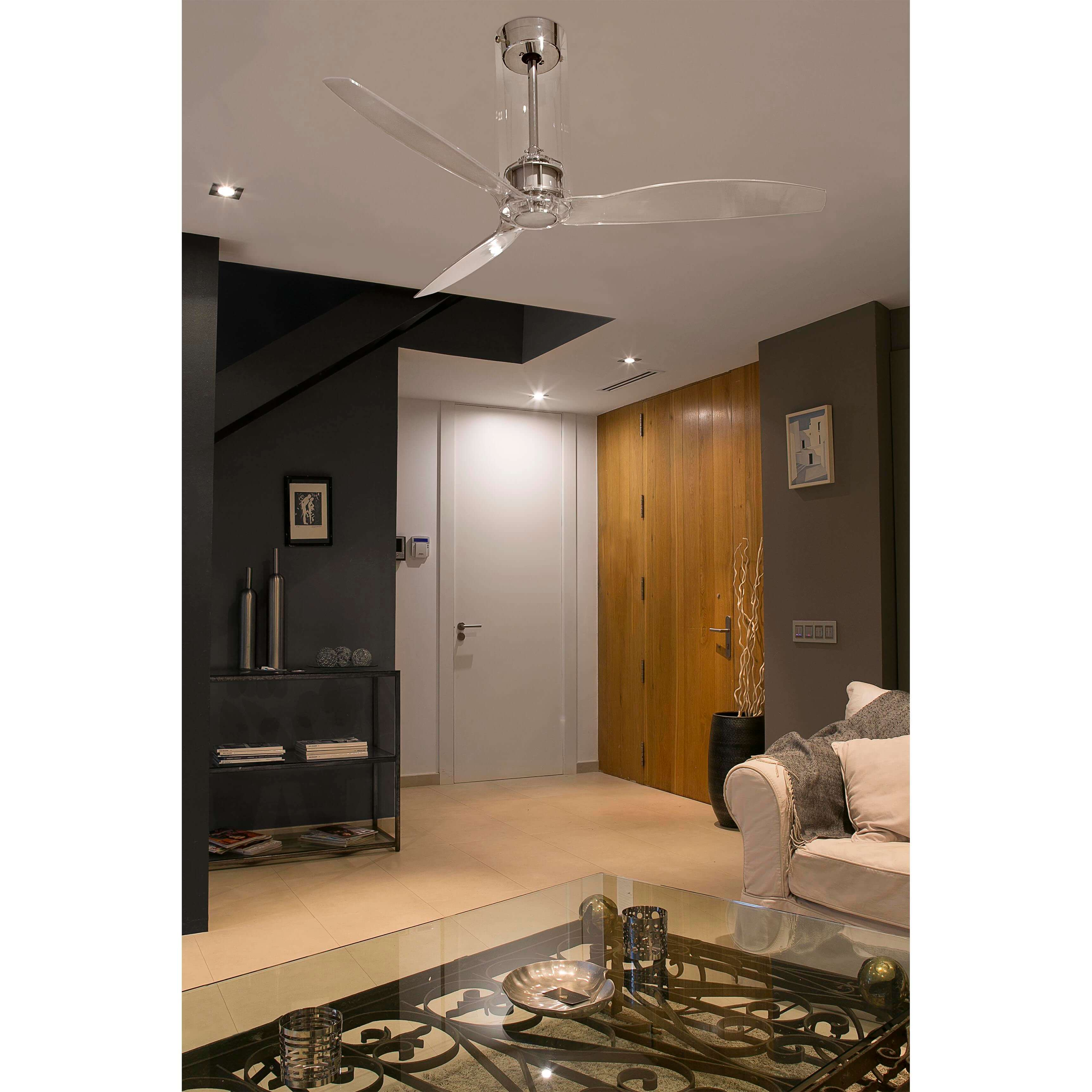 Ein modernes Wohnzimmer mit Deckenventilator, schwarzem Tisch, weißem Sofa und Holzboden.