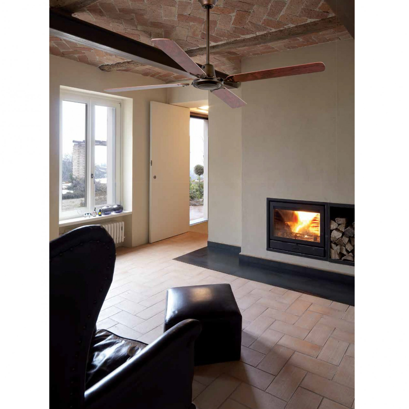 Scena interna con ventilatore a soffitto, camino e poltrona in pelle. Soffitto in mattoni.