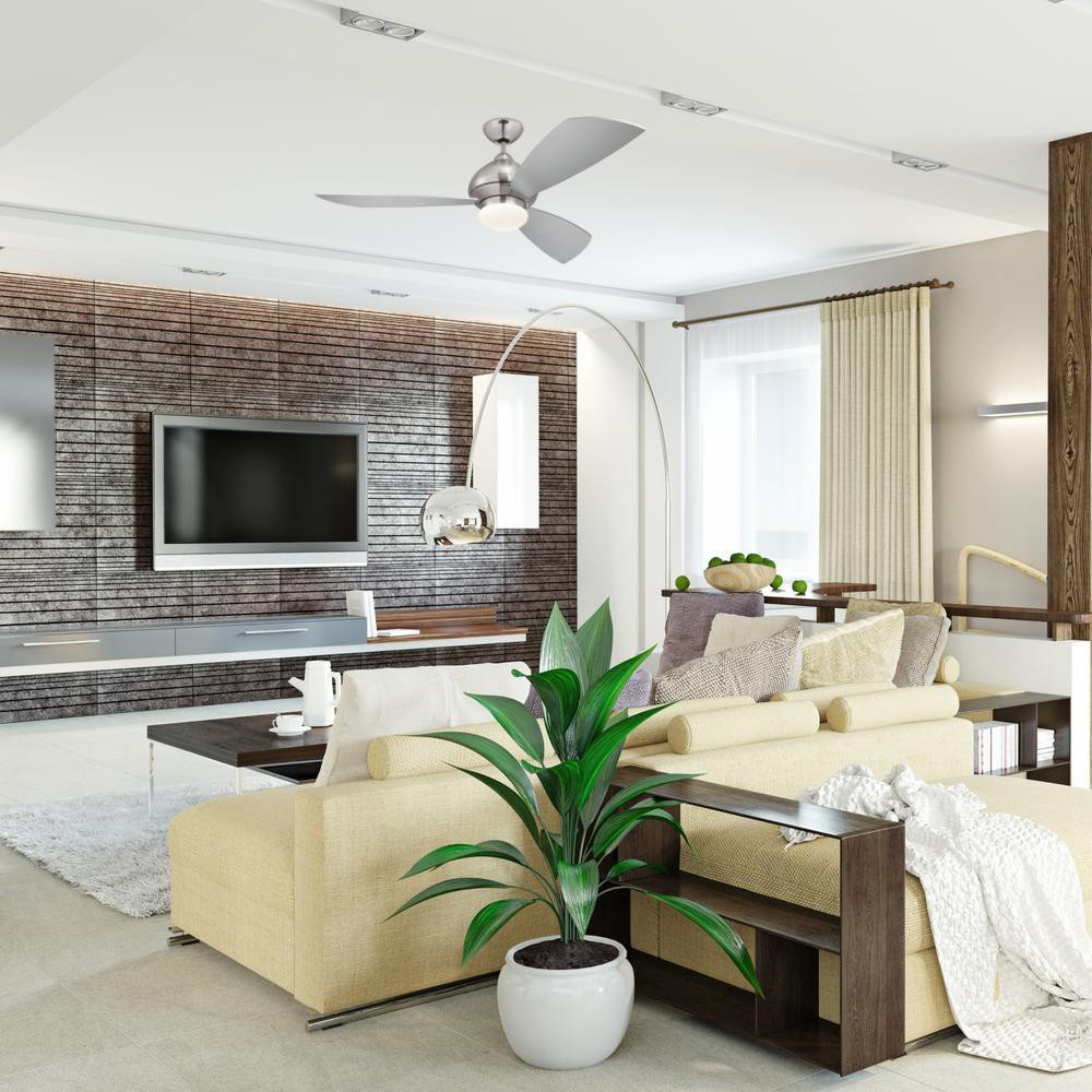 Ein modernes Wohnzimmer mit Deckenventilator und hellfarbigem Sofa. Der Raum ist gut gestaltet.
