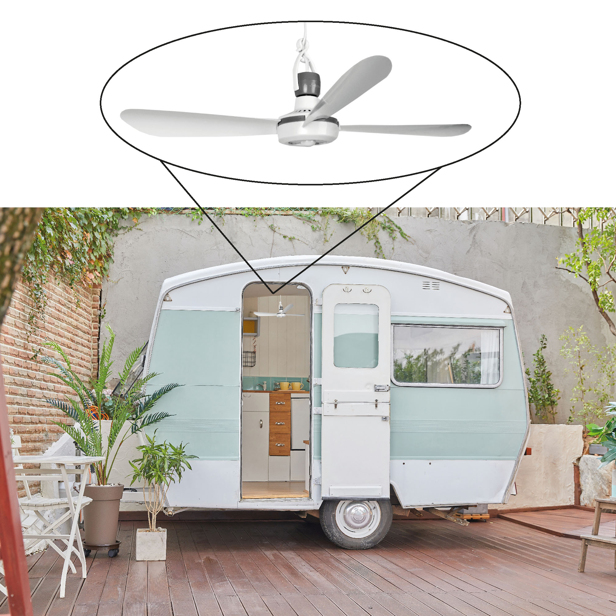Ein weißer Deckenventilator mit drei Flügeln ist über einem teal-weißen Wohnwagen zu sehen.