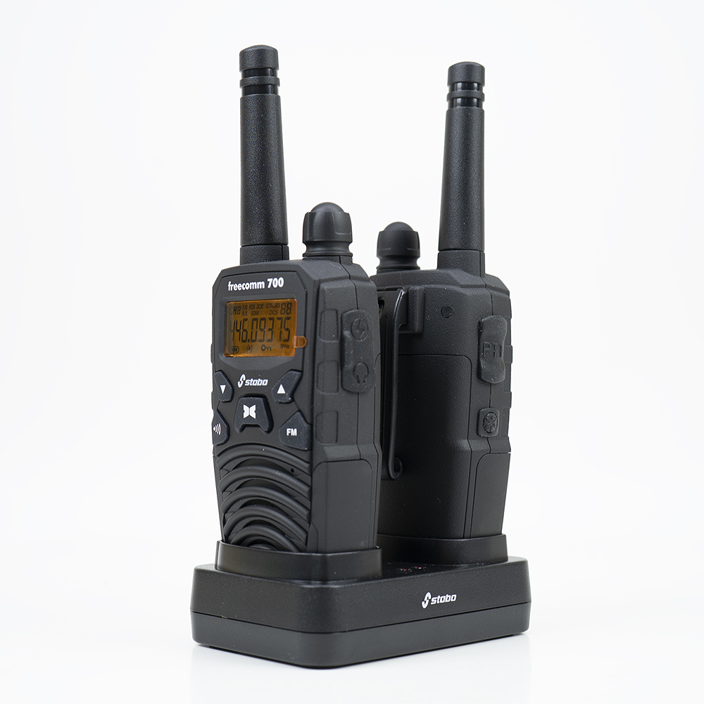 Zwei schwarze Walkie-Talkies auf einer Ladestation. Weißer Hintergrund.