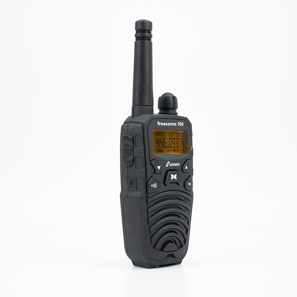 Ein schwarzes Walkie-Talkie auf einer weißen Oberfläche. Es hat einen Bildschirm und Knöpfe.