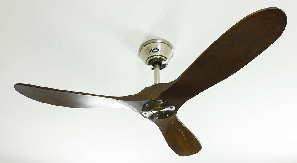 Ventilatore da soffitto con tre pale in legno, montato su un soffitto bianco.