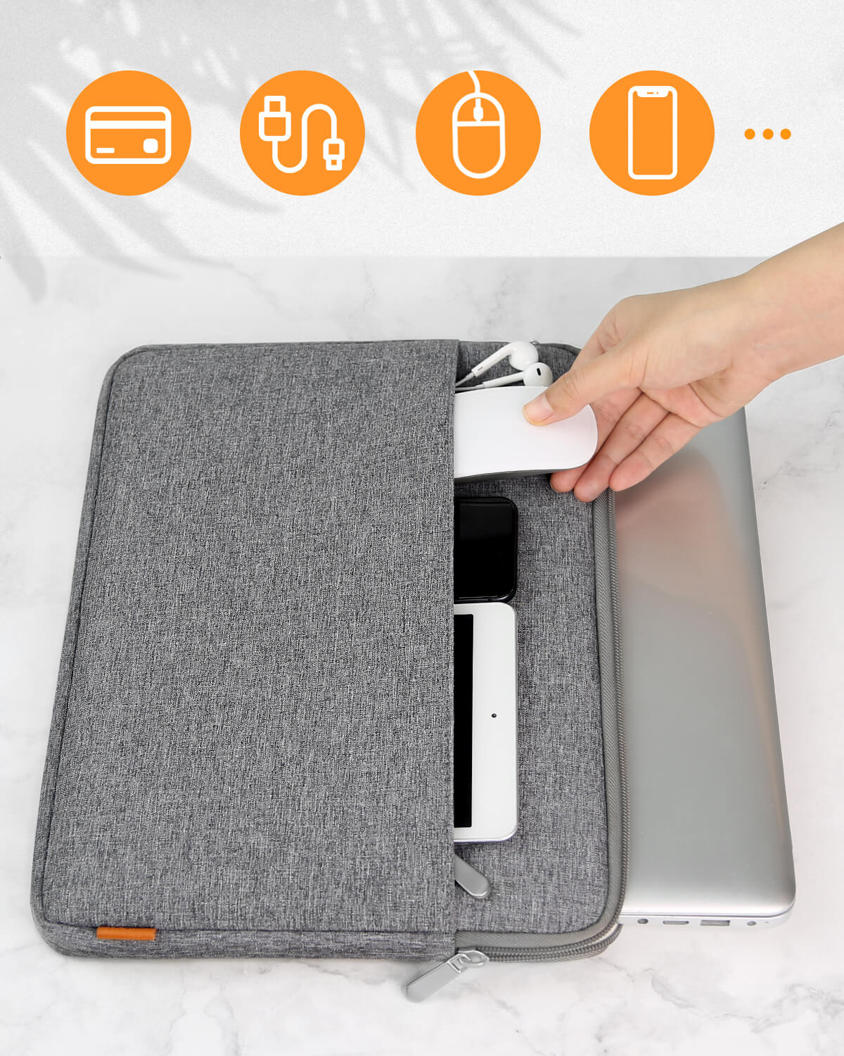 Eine graue Laptoptasche mit Zubehör. Eine Hand nimmt einen weißen Gegenstand heraus.