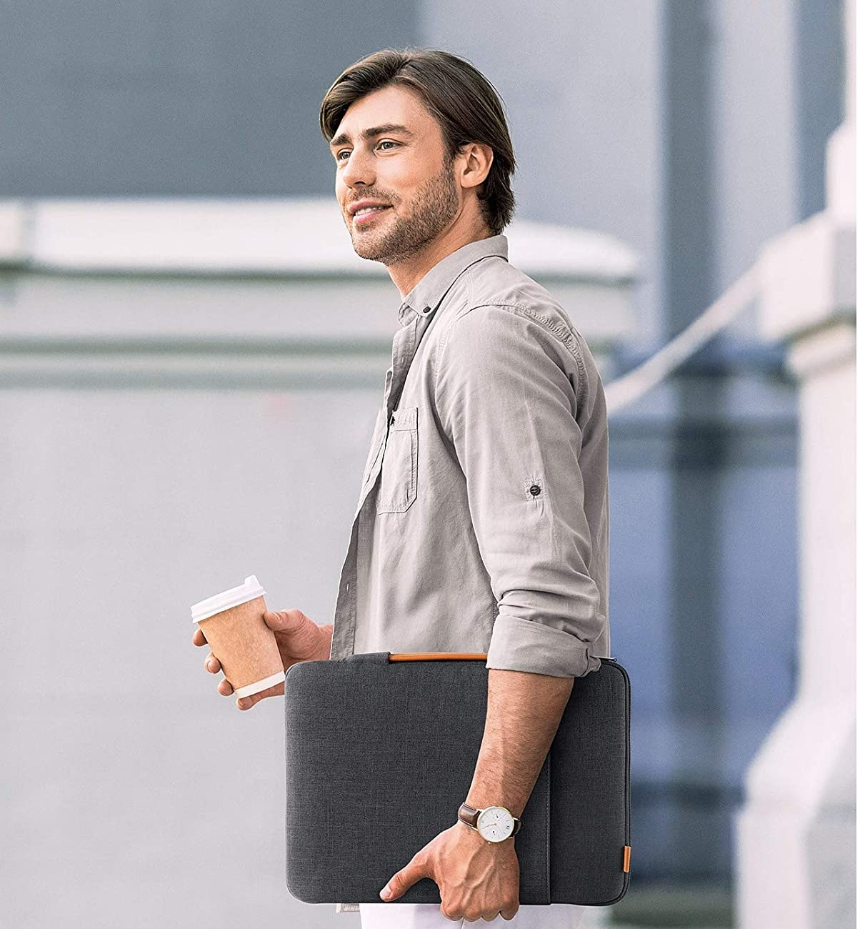 Mann, der eine Kaffeetasse und eine Laptoptasche hält.