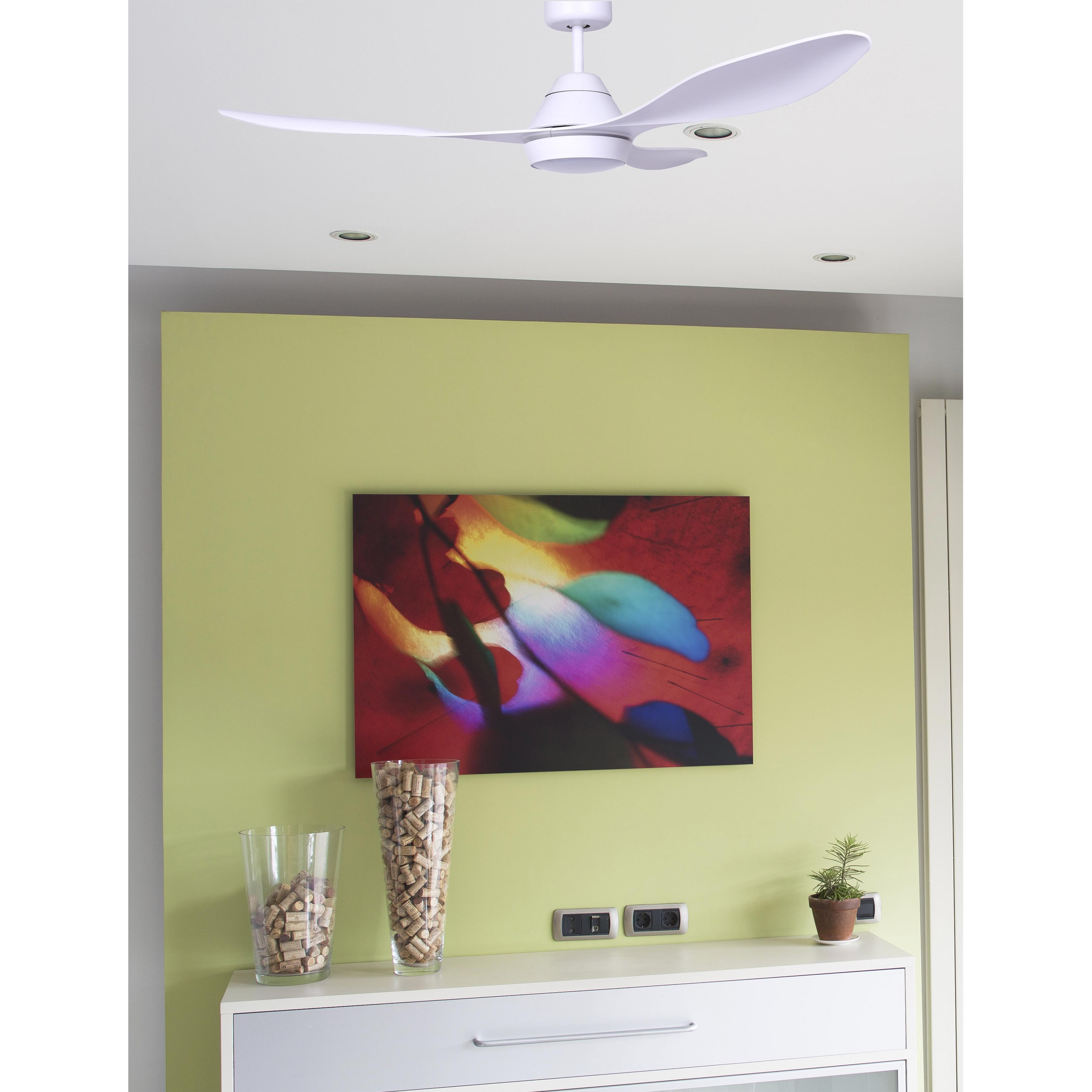 Ventilatore da soffitto bianco con tre pale, montato su un soffitto bianco. Opera d'arte sul muro.