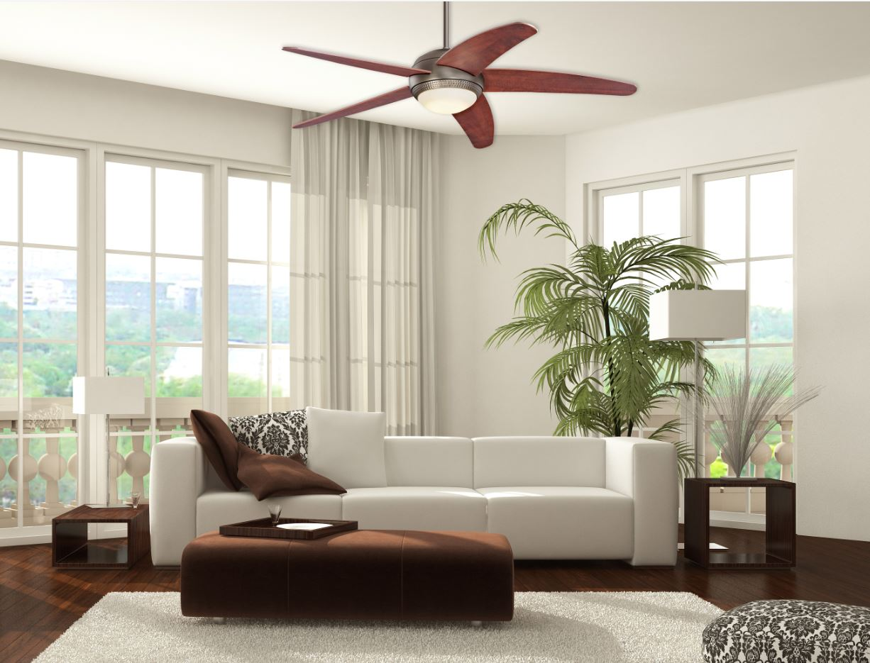 Ein Wohnzimmer mit einem weißen Sofa, einem braunen Ottomanen und einem Deckenventilator.