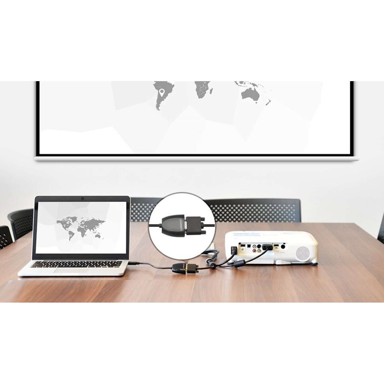 Laptop, projektor i kabel. Laptop jest podłączony do projektora na stole.