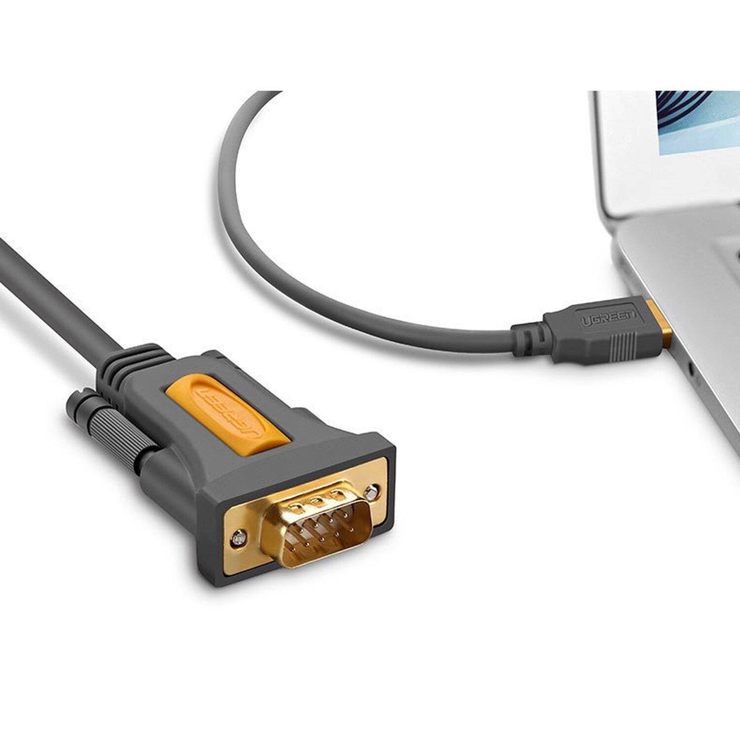 Graues und goldenes VGA-Kabel, das an einen Laptop und einen Adapter angeschlossen ist.