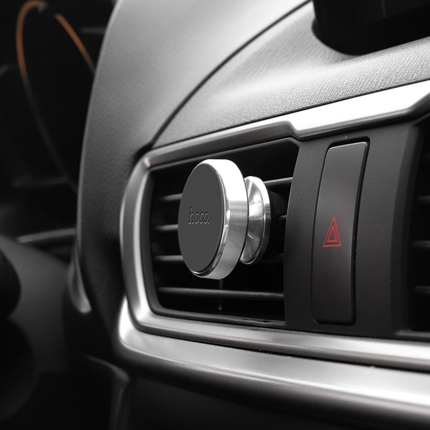 Die Lüftungsöffnung eines Autos mit einem daran befestigten magnetischen Telefonhalter.