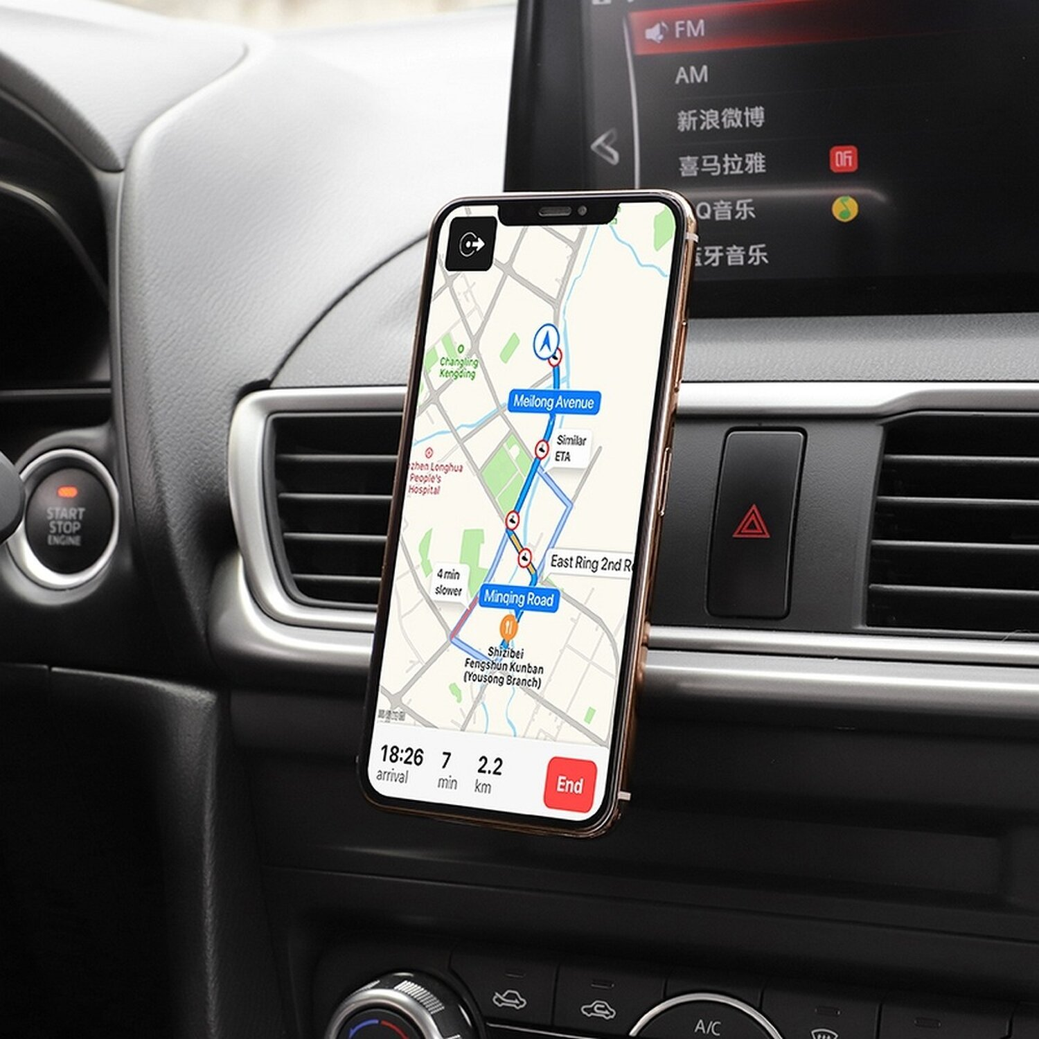 Ein Telefon ist in einem Auto montiert und zeigt eine Karte an. Das Armaturenbrett und ein Teil des Innenraums des Autos sind sichtbar.