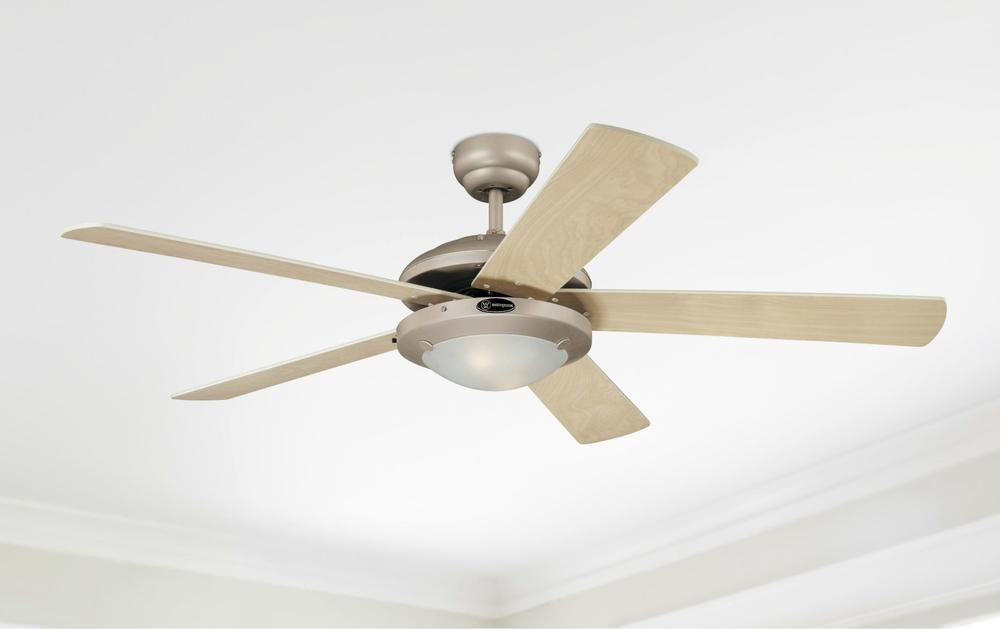 Deckenventilator mit fünf hellen Holzblättern, silbernem Motor und weißer Decke.