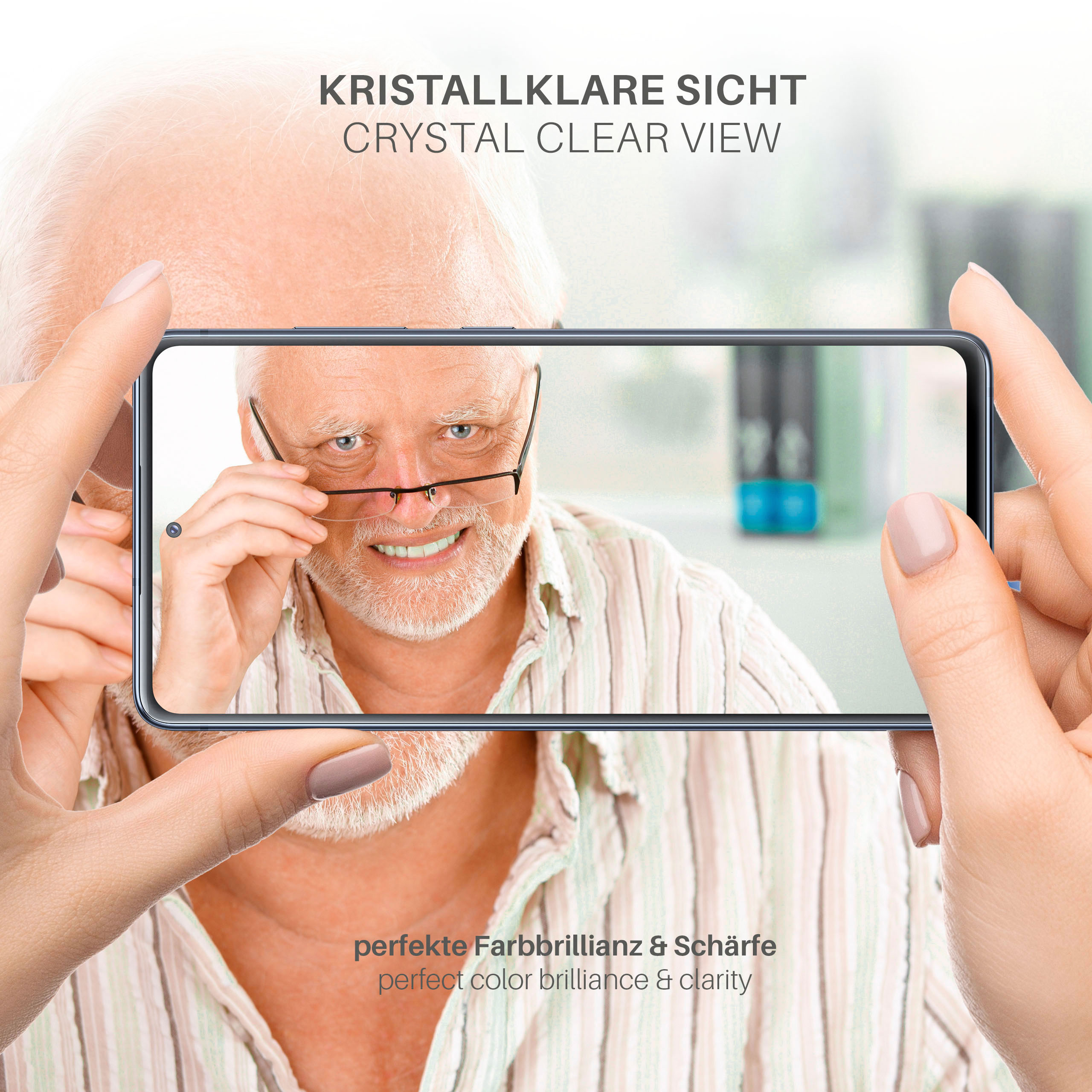 Person hält Telefon mit Mann, der in die Kamera schaut, Brille trägt, mit Textüberlagerung.