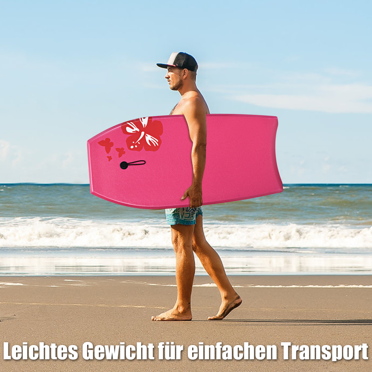 Ein Mann trägt ein pinkes Bodyboard mit rotem Blumendesign am Sandstrand, sonniger Tag.