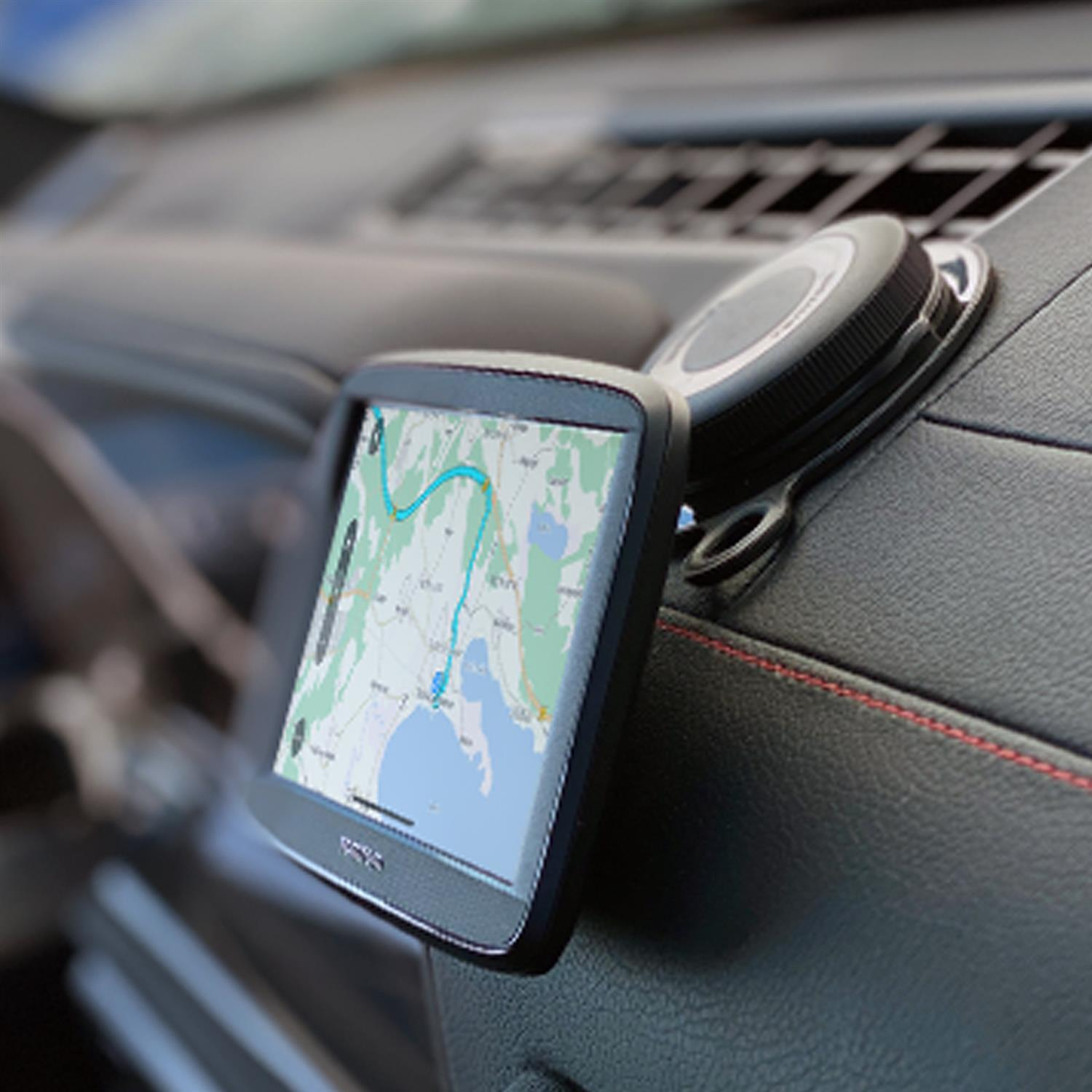 Ein GPS-Gerät ist auf dem Armaturenbrett eines Autos montiert. Der Bildschirm zeigt eine Karte mit einer Route an.