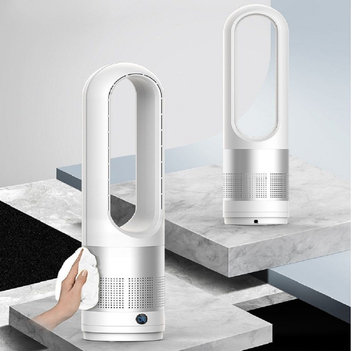 Zwei weiße Ventilatoren auf einem Sockel. Eine Hand hält ein weißes Tuch, das den ersten Ventilator reinigt.