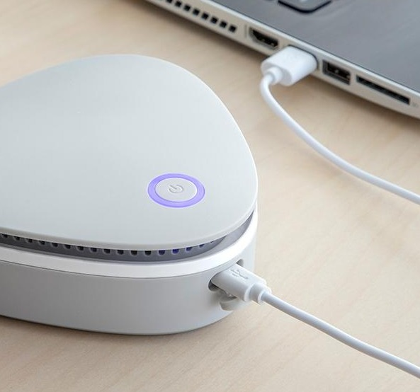 Un dispositivo bianco collegato a un laptop tramite un cavo USB.