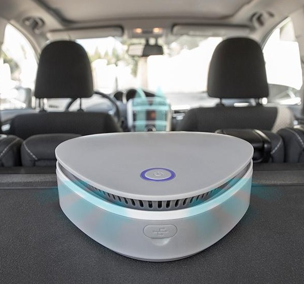 Un purificatore d'aria per auto nella parte posteriore di un'auto. Il purificatore è grigio e di forma ovale.