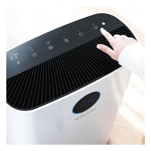Purificatore d'aria bianco e nero. Una mano tocca il pulsante di accensione. Il display digitale blu mostra '045'.