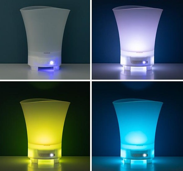 Vier Bilder eines weißen Diffusors mit verschiedenen farbigen Lichtern: weiß, lila, gelb, blau. Schwarzer Hintergrund.