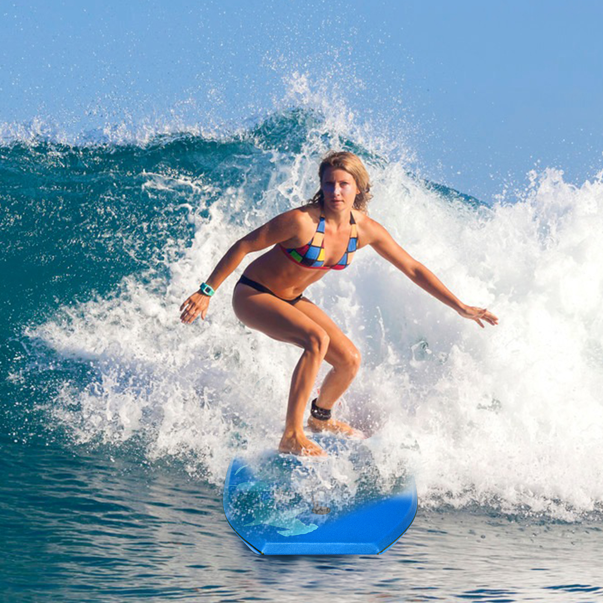 Eine Frau surft auf einem blauen Surfbrett mit einer brechenden Welle im Hintergrund.