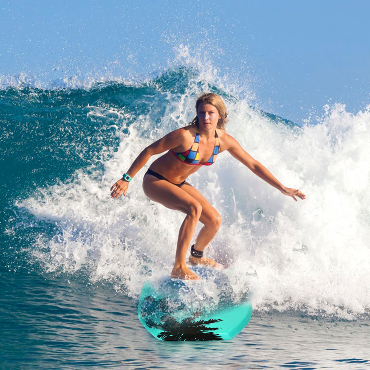 Frau surft eine Welle in einem Bikini auf einem türkisfarbenen Surfbrett.