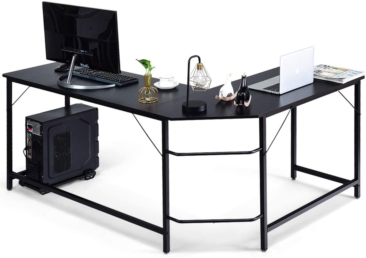 L-förmiger schwarzer Schreibtisch mit Computer, Zubehör und Laptop, weißer Hintergrund.