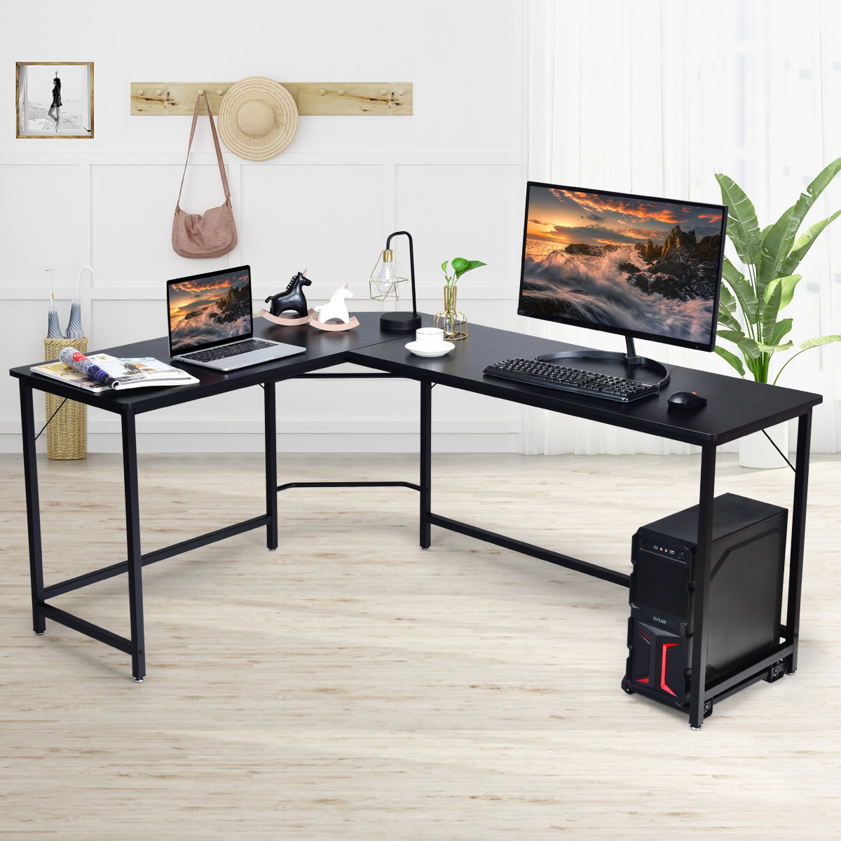 L-förmiger schwarzer Schreibtisch mit Laptop, Monitor, Lampe und Computer. Weiße und beige Wand.