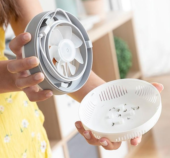 Zerlegte Mückenfalle mit Ventilator und Behälter mit Mücken.