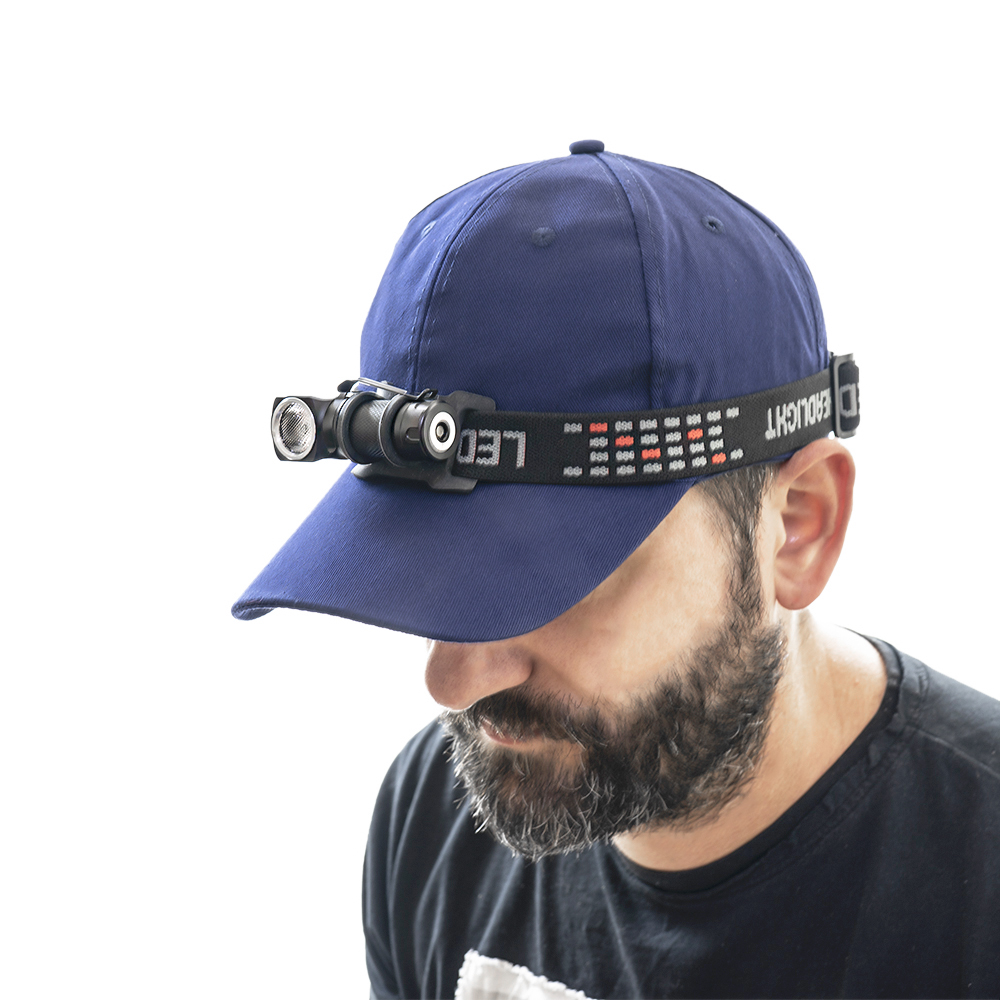 Ein Mann mit blauer Kappe und Stirnlampe. Die Stirnlampe ist am Schirm befestigt.