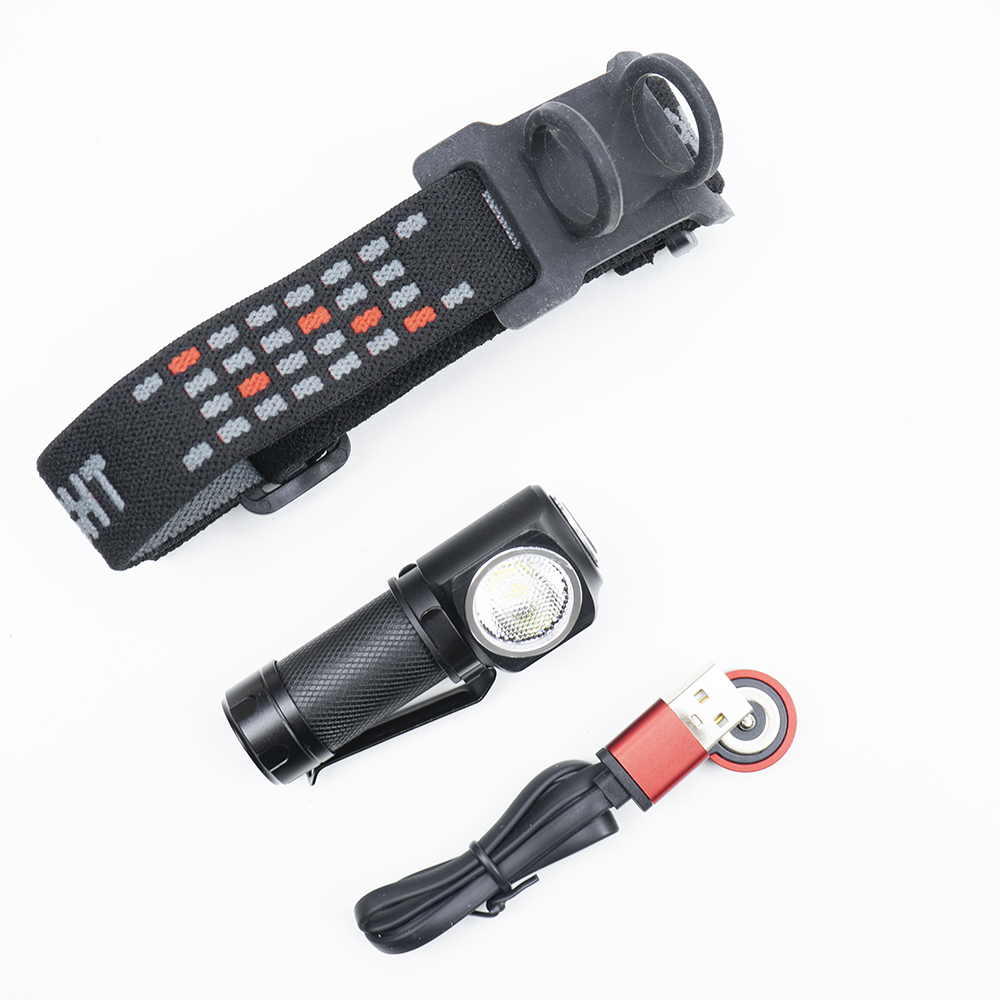 Stirnlampe und Ladegerät auf Weiß. Stirnband, Taschenlampe und USB-Ladegerät mit roter Spitze.